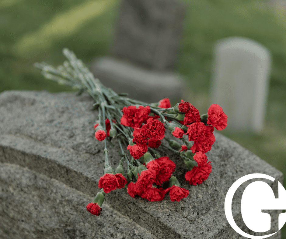 Flowers on top of a grave stone in a cemetery