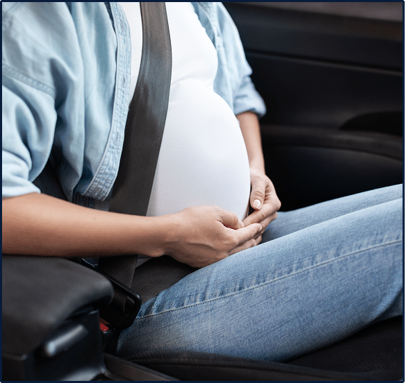 Cropped pregnant lady sitting in driver's seat with safety belt