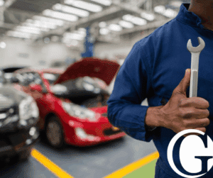 Closeup of mechanic holding a wrench with auto shop blurred out in the background