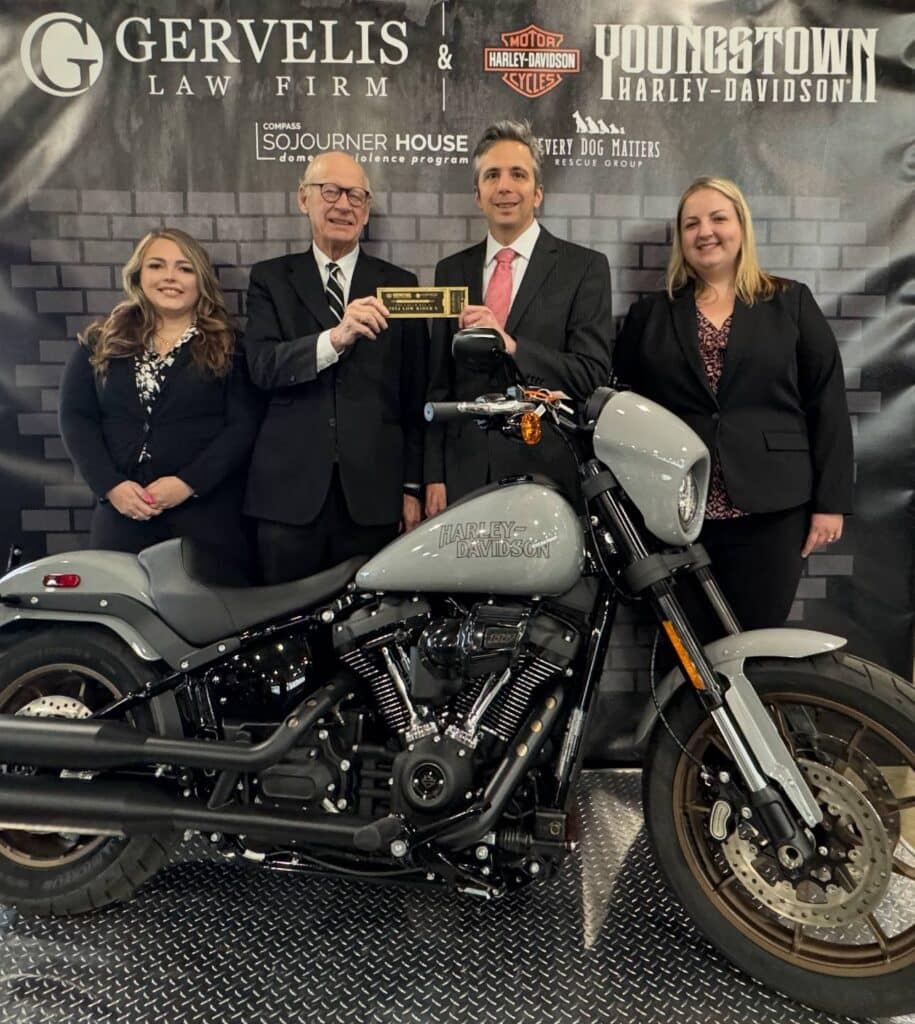 Gervelis team poses with Harley Davidson motorcycle that they're giving away in partnership with Youngstown Harley Davidson