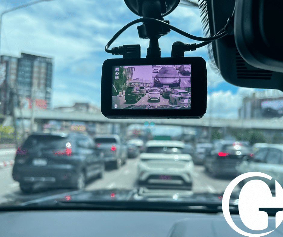 Close up of dash cam on front windshield of car overlooking traffic