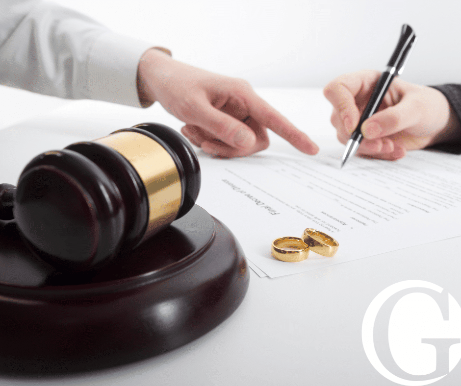 Close up of gavel with two hands in the background working on paperwork