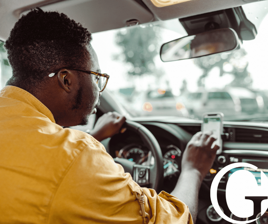 Rideshare driving touching their phone propped up on the dash