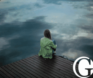 Woman with her back to the camera facing a lake