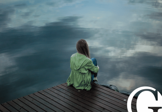 Woman with her back to the camera facing a lake
