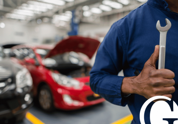 can_insurance_force_you_to_use_their_body_shop Closeup of mechanic holding a wrench with auto shop blurred out in the background